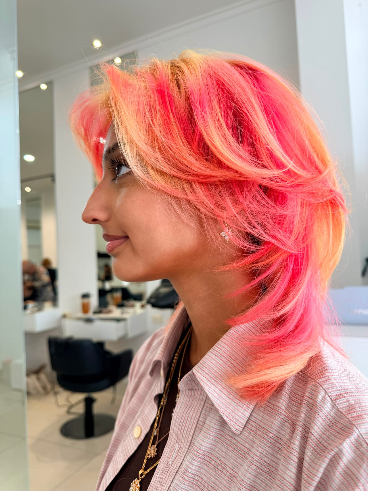 Coral and peach shag haircut with a curtain fringe by UNIK Hair Design